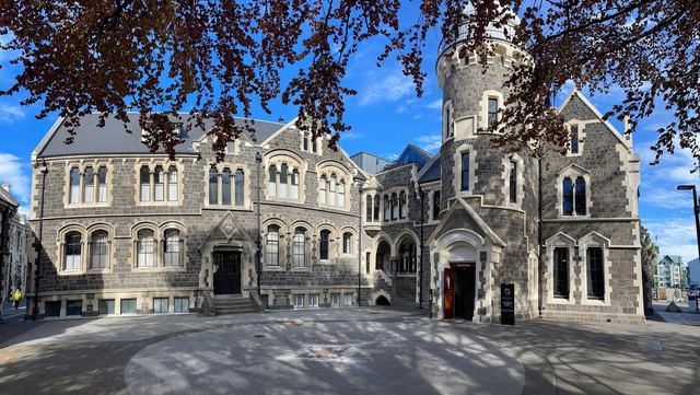 The Gothic Revival stone buildings of the Christchurch Arts Centre under a blue sky.