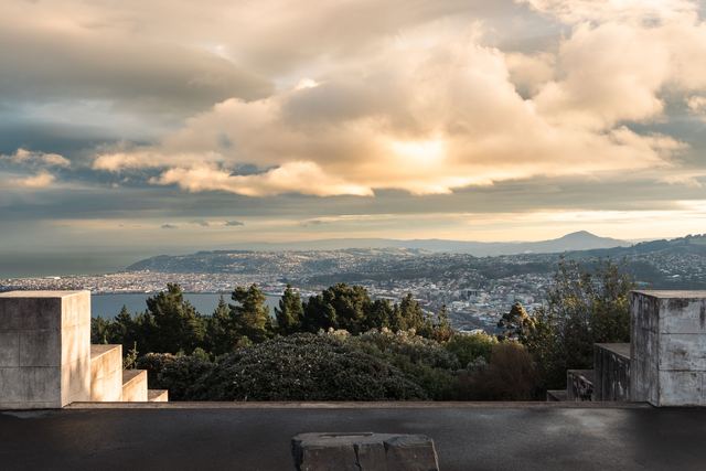 View over Dunedin and its harbour hills from a city lookout at sunset.