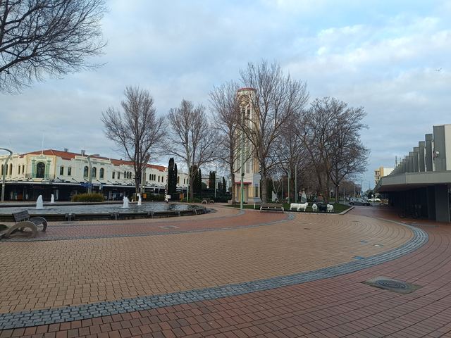 The Hastings clock tower and paved central plaza with fountains and sheep sculptures.