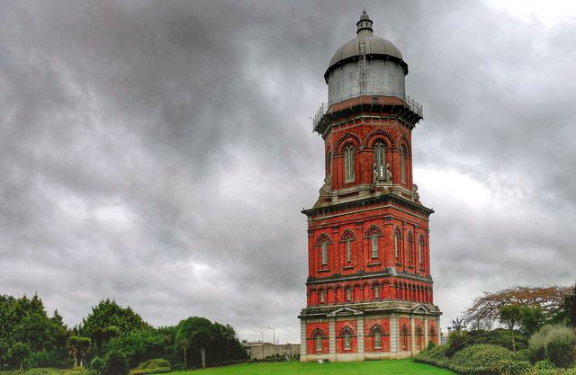 The red-brick Invercargill Water Tower under a cloudy sky.