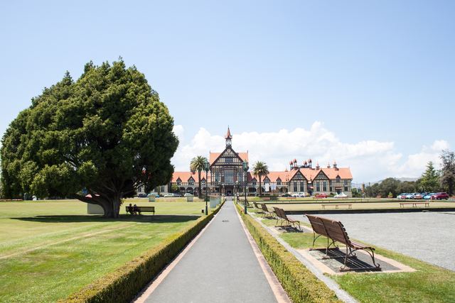The Tudor-style Rotorua Museum building behind the lawns and paths of Government Gardens.